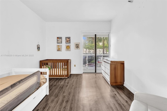 bedroom featuring access to outside, baseboards, and wood finished floors