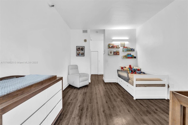 bedroom with dark wood-style flooring, visible vents, and baseboards