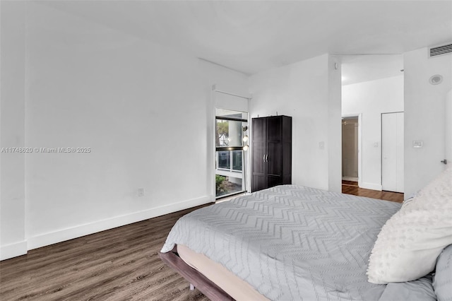 bedroom featuring visible vents, baseboards, and wood finished floors