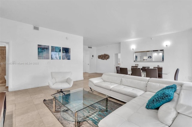 living area featuring tile patterned flooring, visible vents, and baseboards