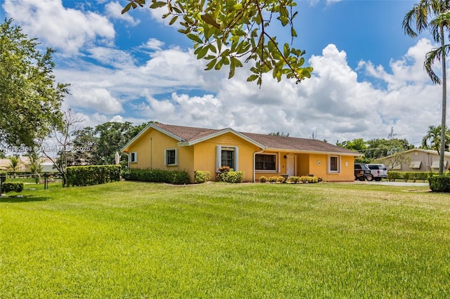 single story home featuring fence, a front lawn, and stucco siding