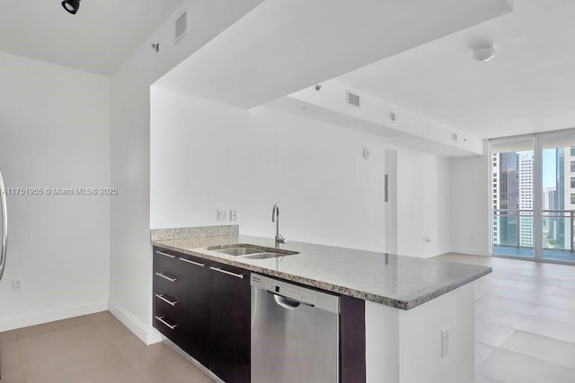 kitchen featuring a sink, visible vents, baseboards, dishwasher, and a wall of windows