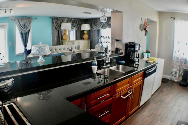 kitchen featuring dark wood-style floors, dark countertops, open floor plan, a sink, and dishwashing machine