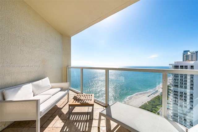 balcony with a water view, a beach view, and outdoor lounge area