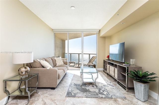 living area featuring baseboards and floor to ceiling windows