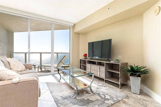 living room featuring a wall of windows, a textured ceiling, and baseboards