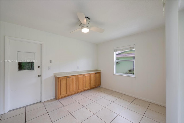 empty room with a ceiling fan and light tile patterned floors