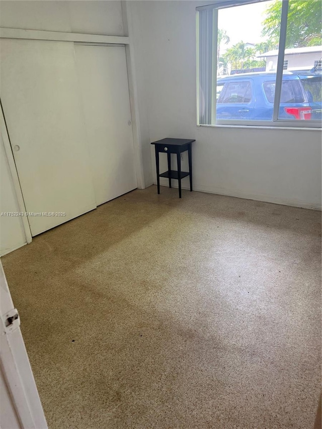 unfurnished bedroom with a closet and speckled floor