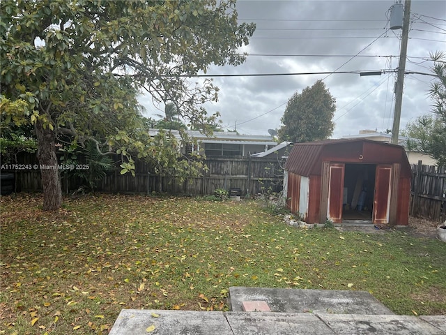 view of yard with an outbuilding, a shed, and a fenced backyard