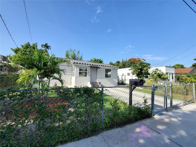 view of front of home featuring a fenced front yard, a gate, and stucco siding