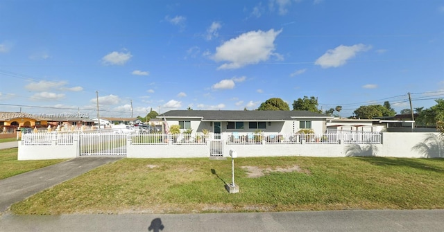 view of front facade with a fenced front yard, a gate, and a front lawn