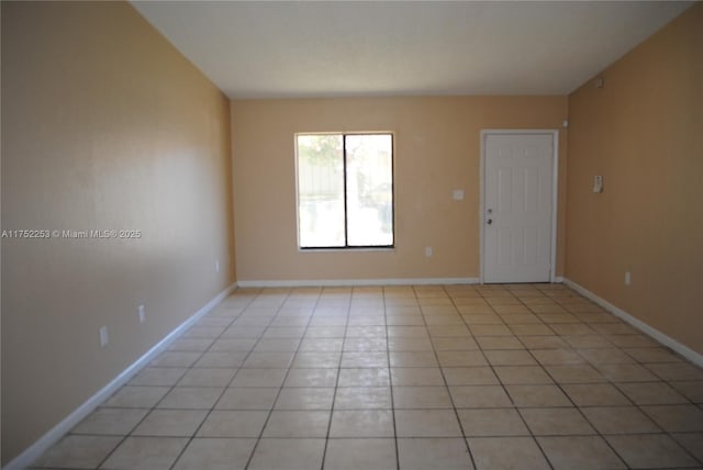 unfurnished room with light tile patterned flooring and baseboards