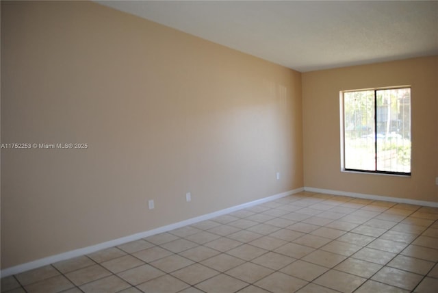 unfurnished room featuring light tile patterned flooring and baseboards