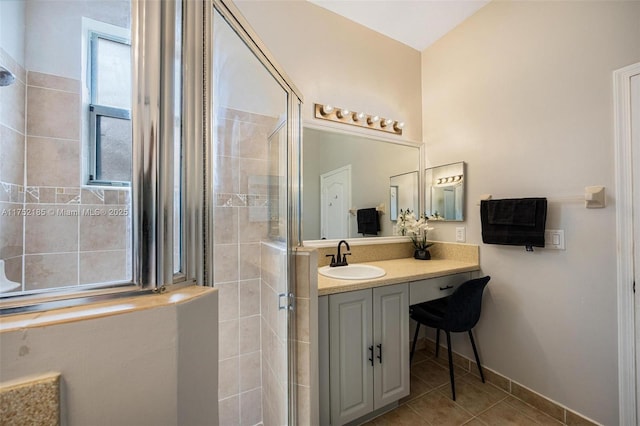 bathroom with baseboards, a shower stall, vanity, and tile patterned floors