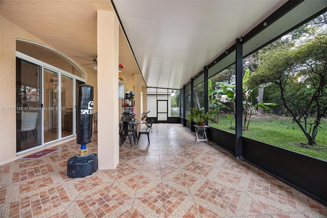 unfurnished sunroom featuring ceiling fan