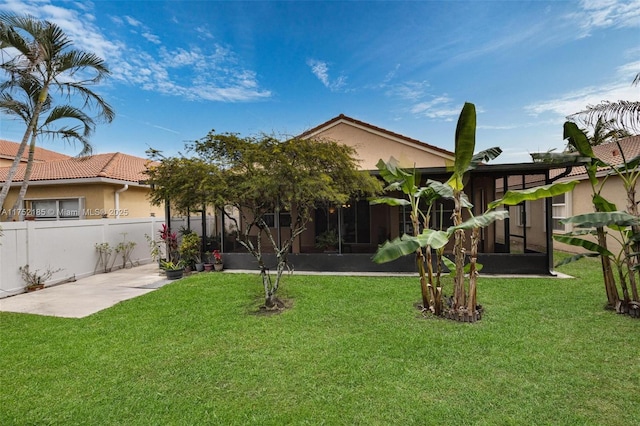 back of property featuring a fenced backyard, a lawn, and stucco siding