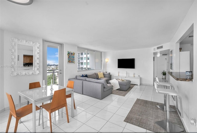 living room featuring light tile patterned floors, visible vents, and baseboards