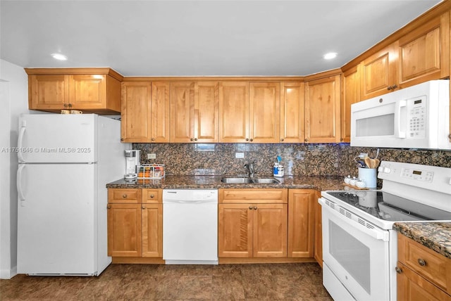 kitchen with white appliances, decorative backsplash, brown cabinets, dark stone countertops, and a sink