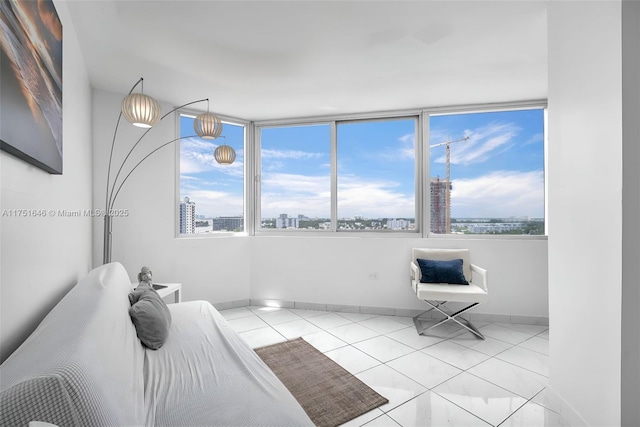 bedroom with a view of city, baseboards, and tile patterned floors