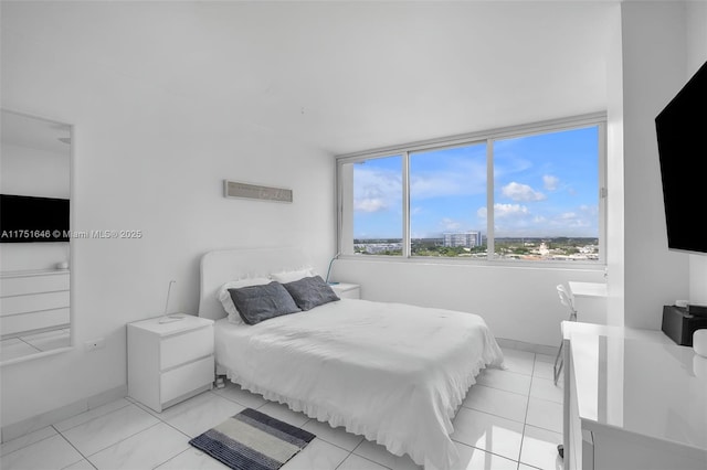 bedroom with light tile patterned flooring and baseboards