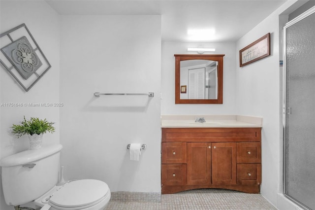 bathroom featuring vanity, a shower stall, and toilet