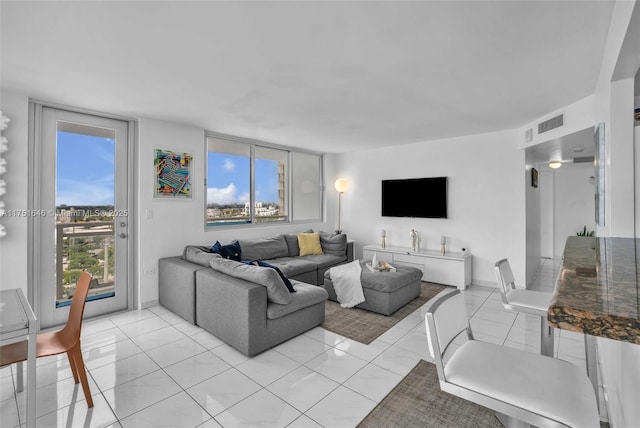 living room with visible vents, baseboards, and light tile patterned floors