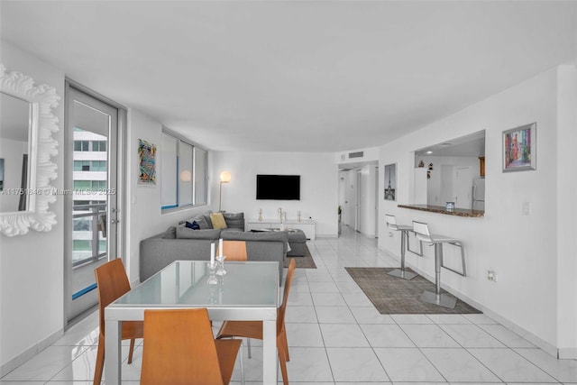 dining room with light tile patterned floors, baseboards, and visible vents