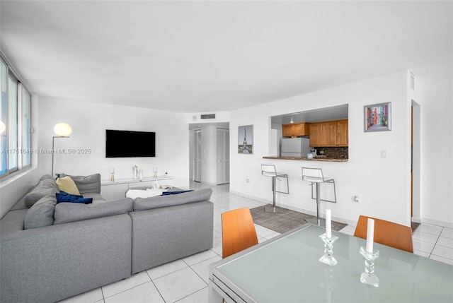 living area featuring visible vents and light tile patterned floors