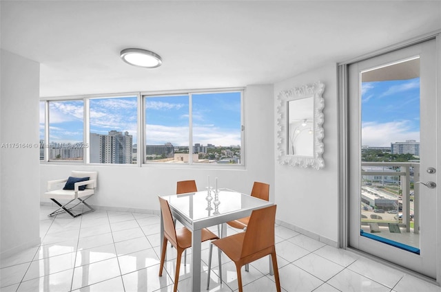 dining space with a view of city, baseboards, and light tile patterned floors