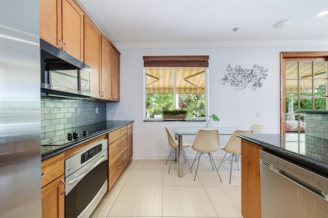 kitchen with tasteful backsplash, brown cabinets, stainless steel appliances, crown molding, and light tile patterned flooring