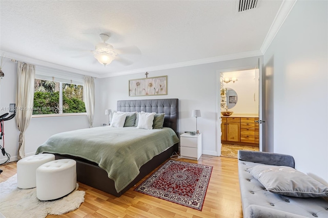 bedroom with baseboards, visible vents, wood finished floors, crown molding, and a textured ceiling