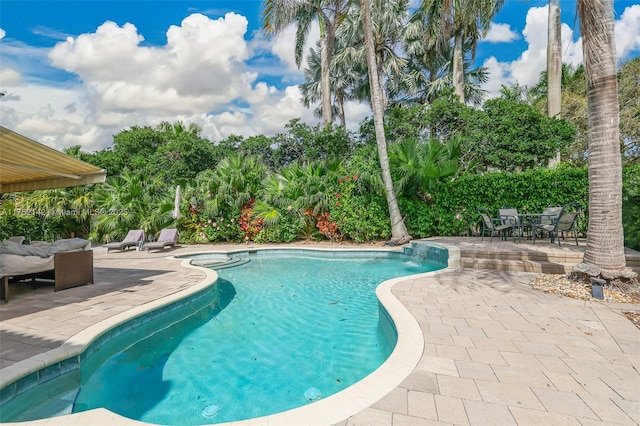 pool featuring a hot tub and a patio