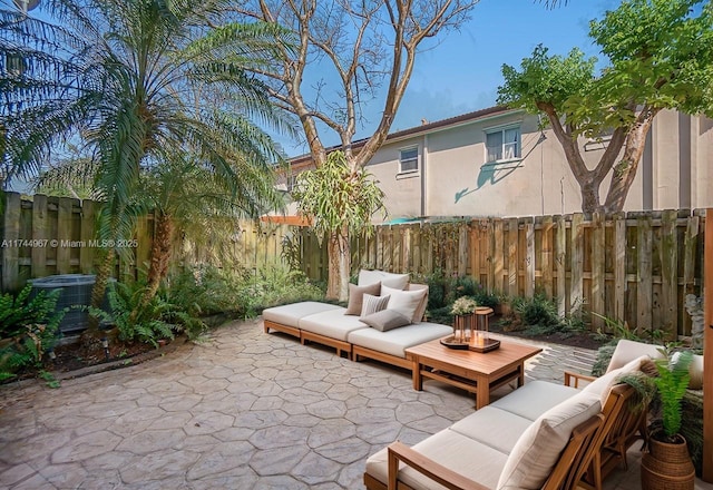 view of patio featuring a fenced backyard, an outdoor living space, and cooling unit