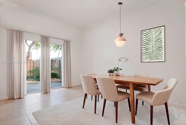 dining room featuring crown molding, light tile patterned floors, and baseboards