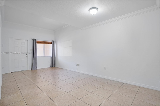 spare room featuring ornamental molding, a textured ceiling, baseboards, and light tile patterned floors