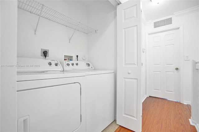 laundry area featuring laundry area, light wood-style flooring, visible vents, and washer and clothes dryer