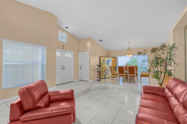 living room with baseboards, visible vents, vaulted ceiling, and light tile patterned flooring