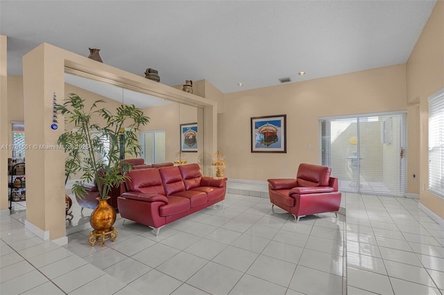 living room featuring light tile patterned floors, visible vents, and baseboards