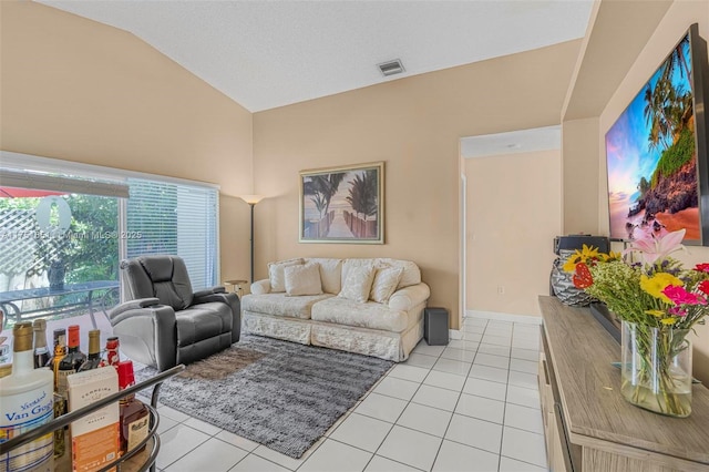 living room with lofted ceiling, light tile patterned flooring, and visible vents