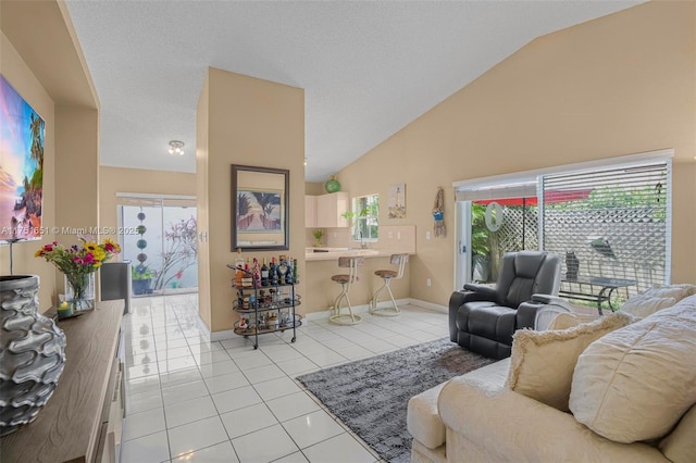 living room featuring lofted ceiling, light tile patterned floors, baseboards, and a textured ceiling