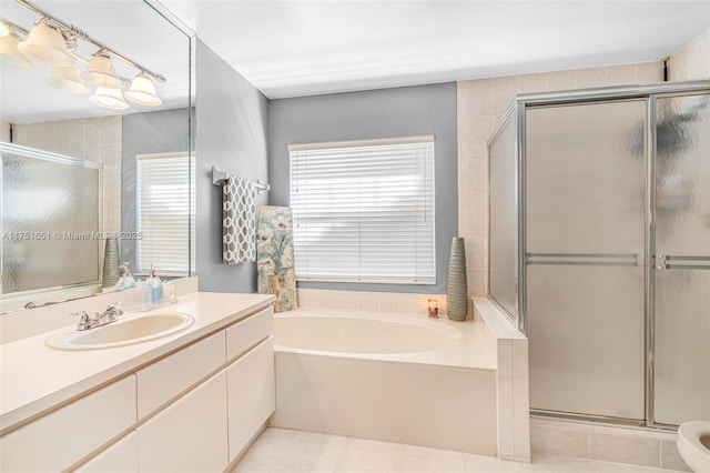 bathroom with a shower stall, vanity, a bath, and tile patterned floors