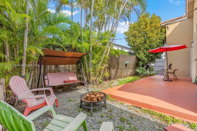 view of patio / terrace featuring fence and a fire pit