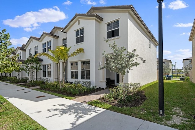 view of front of property with a front yard, a residential view, and stucco siding