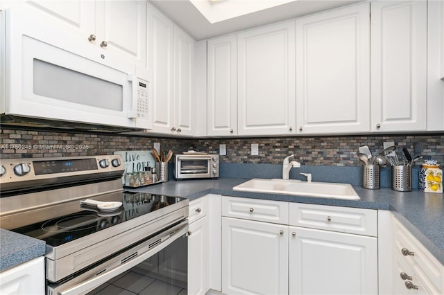 kitchen with electric stove, white cabinets, a sink, and white microwave