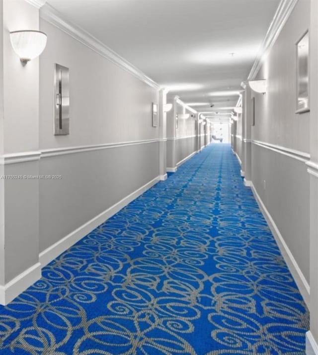 hall featuring carpet, ornamental molding, and baseboards