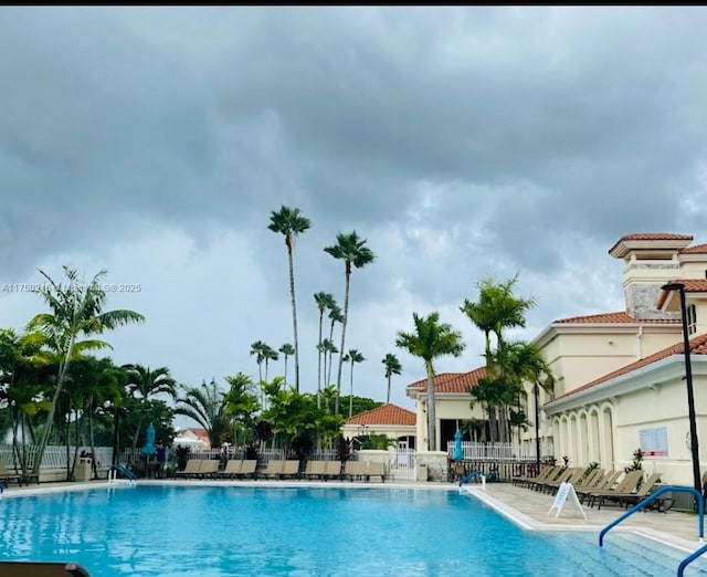 community pool with fence and a patio