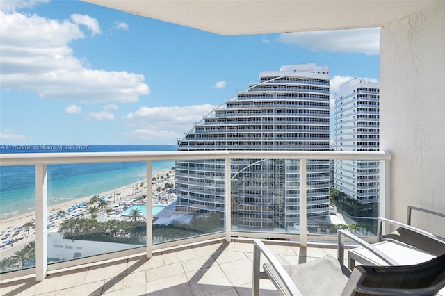 balcony with a water view, a city view, and a view of the beach