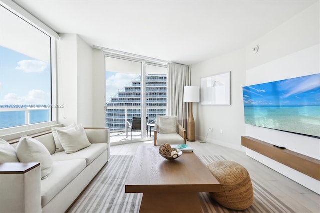 living room with a water view, expansive windows, baseboards, and a wealth of natural light