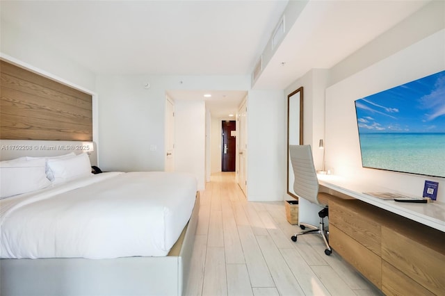 bedroom featuring light wood-style flooring and built in study area