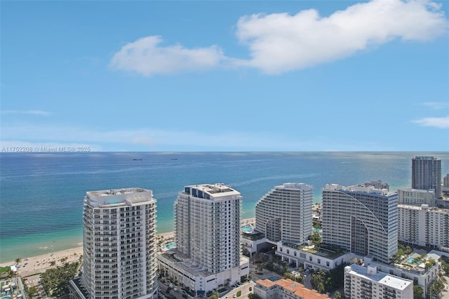 drone / aerial view with a water view, a beach view, and a city view